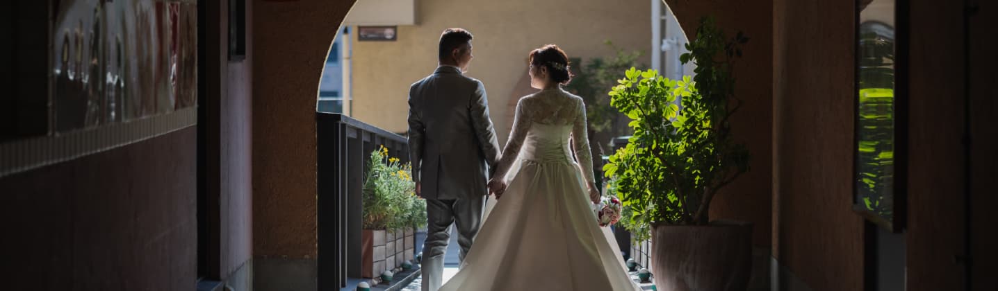 結婚式場で新郎新婦が手を繋いでいる様子